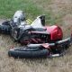 Motorcycle broken and wrecked on grass because of an accident.